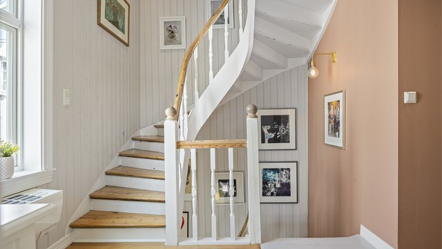 Den svingete tretrappen binder etasjene sammen og er et sjarmerende element i boligen.