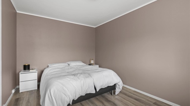 Romslig hovedsoverom med god plass til både dobbeltseng og tilhørende nattbord på hver side.