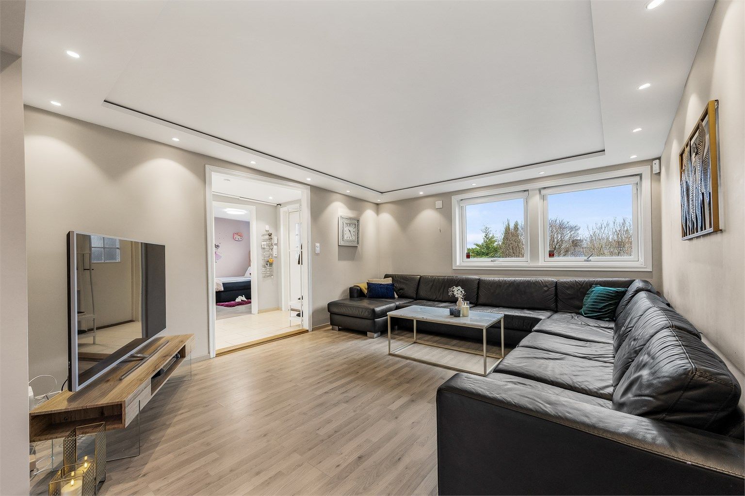 Store vindusflater gir godt med lys, og rommet har god plass til en stor sofagruppe.