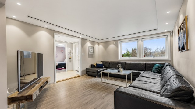 Store vindusflater gir godt med lys, og rommet har god plass til en stor sofagruppe.