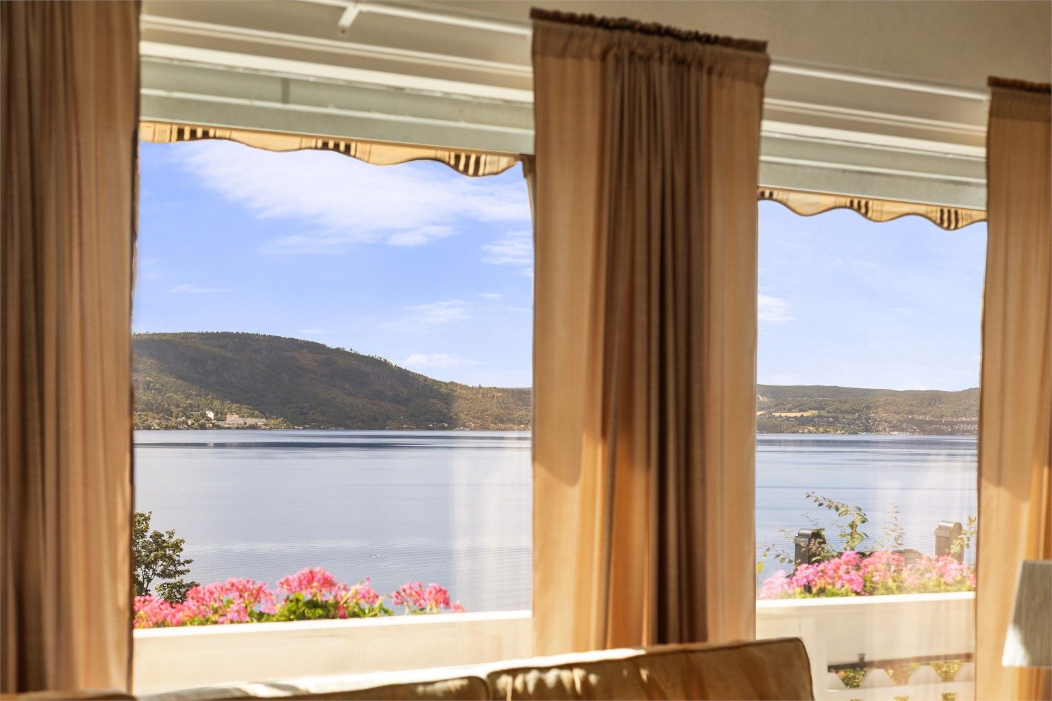 De store vindusflatene i stuen rammer inn utsikten mot fjorden.