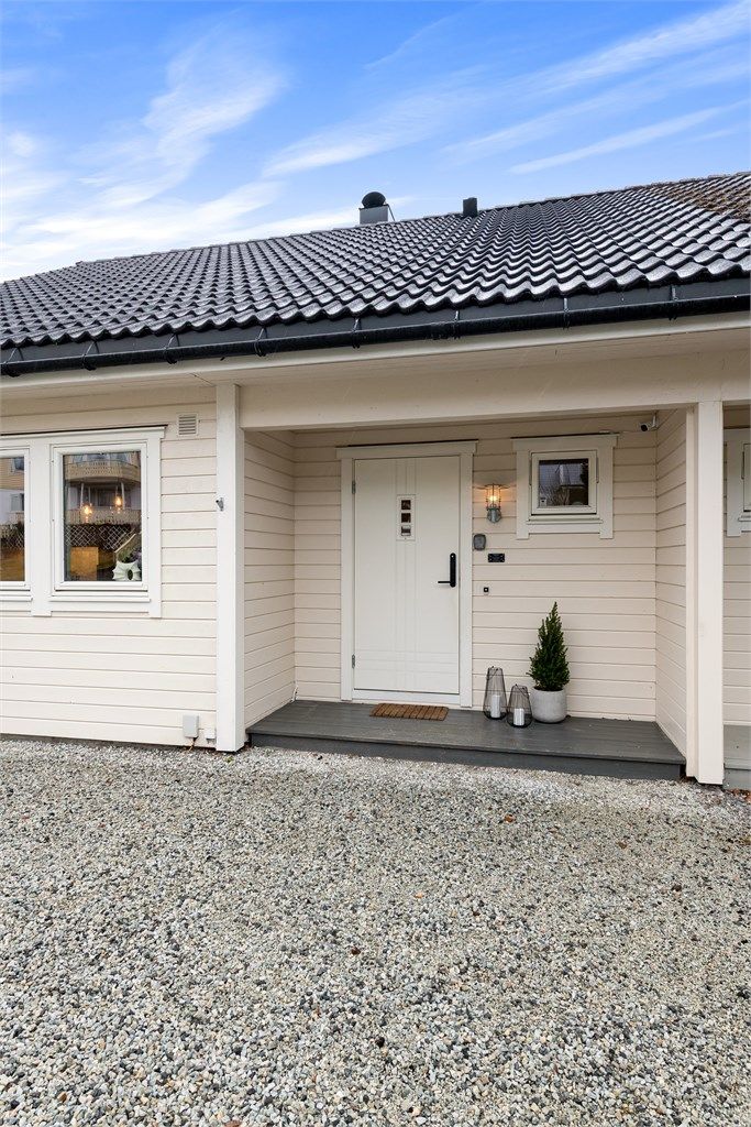 Overbygget inngangsparti med entrédør utstyrt med elektronisk kodelås.