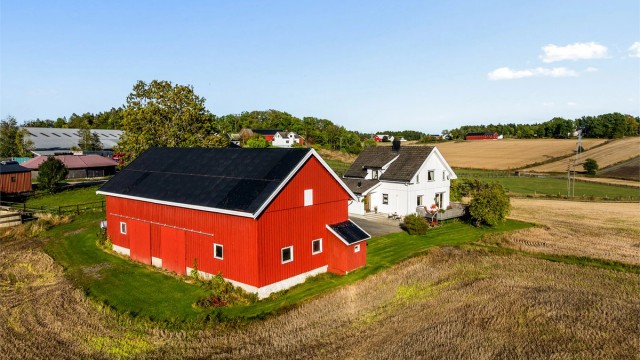 Den store låven og våningshuset ligger skjermet til med god avstand mellom bygningene.