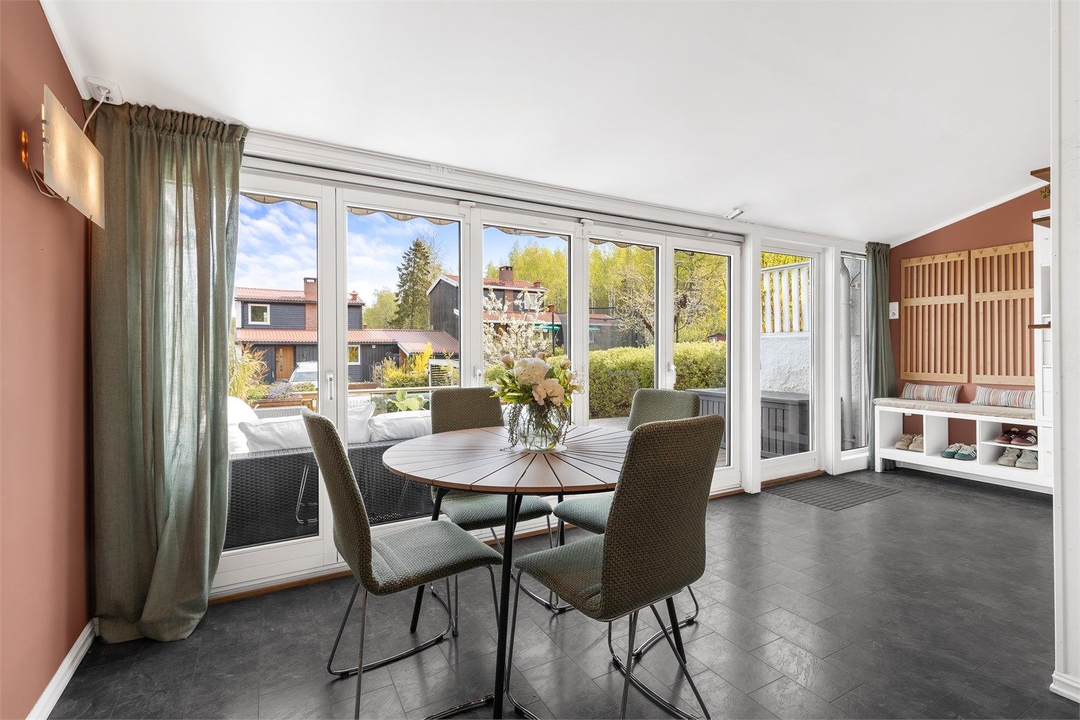 Boligens spisestue har store vindusflater som slipper inn rikelig med naturlig lys.