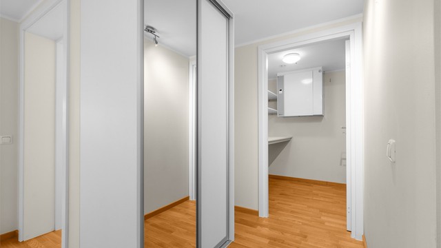 Romslig gang med praktisk skyvedørsgarderobe med speilfront