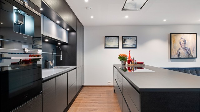 Kjøkkenet har integrert kjøleskap, fryseskap, oppvaskmaskin, induksjonstopp, vinskap, kaffemaskin samt stekeovn/kombiovn.