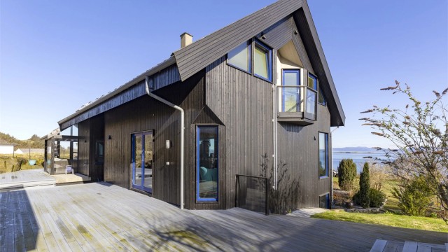 Store terrasseområder i trekonstruksjon omkranser boligen og skaper mange fine uteplasser.