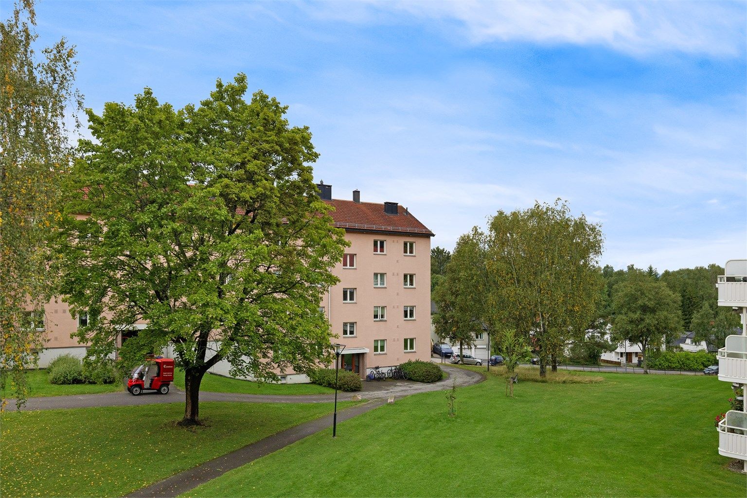 Hyggelig og grønt utsyn over borettslagets fellesområder fra balkongen