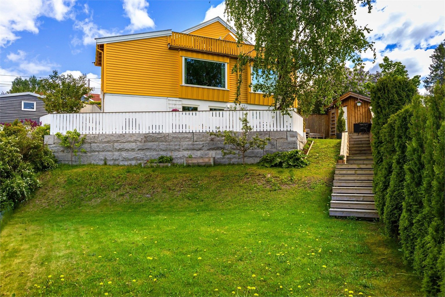 Boligen har flotte nydelige uteplasser både med takterrasse, uteplass og frodig hage med bærbusker og frukttrær
