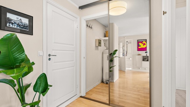 Entré med skyvedørsgarderobe for praktisk oppbevaring av yttertøy og sko.