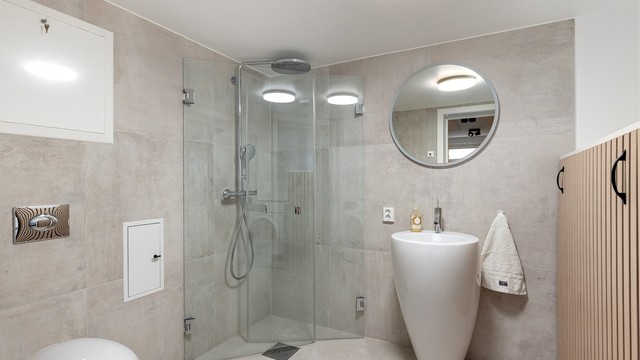 Lekker flislagt bad/wc med dusjhjørne med svingbare glassdører, vegghengt toalett, opplegg for vaskemaskin og gulvvarme. Varmtvannstank for snr.1 og 2 er pent bygd inn i spileinnredning