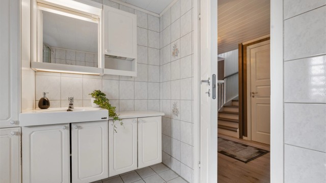 Praktisk innredning med servant og ettgreps armatur, samt høyskap og overskap med speil og belysning med tilhørende stikkontakt.