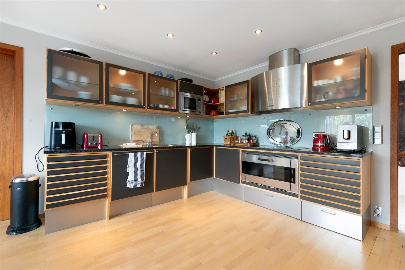 Kjøkkeninnredning fra Uno Form med benkeplate i stein og integrert stekeovn fra Gaggenau. Stål ventilator. 