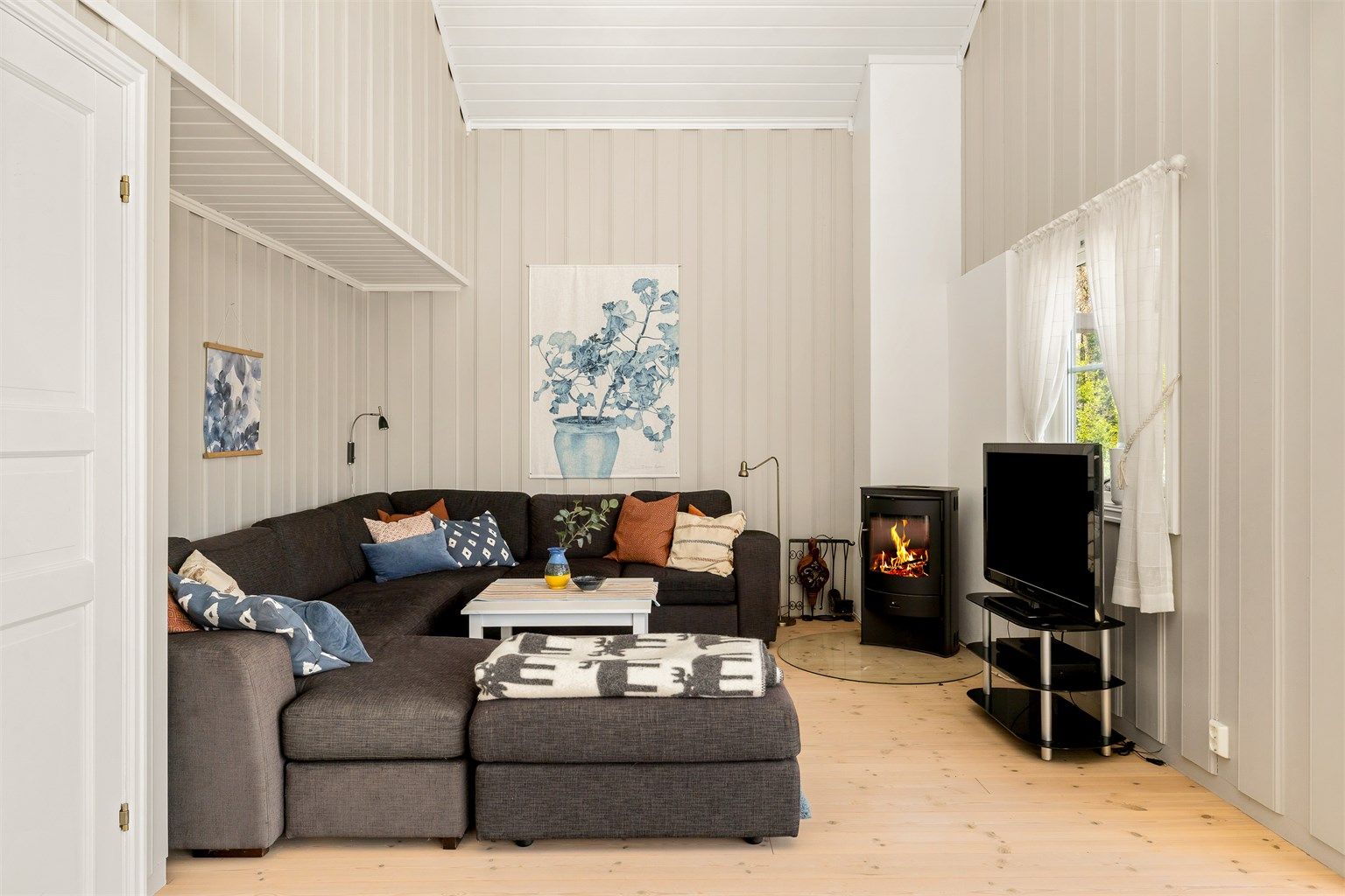 Stuen har god plass til både sofa og lesekrok, takhøyden på ca. 5 meter sørger for en god romfølelse.
