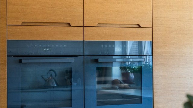 Hvitevarene er integrert i en heltre eikevegg, med blant annet komfyr og dampovn fra Miele.