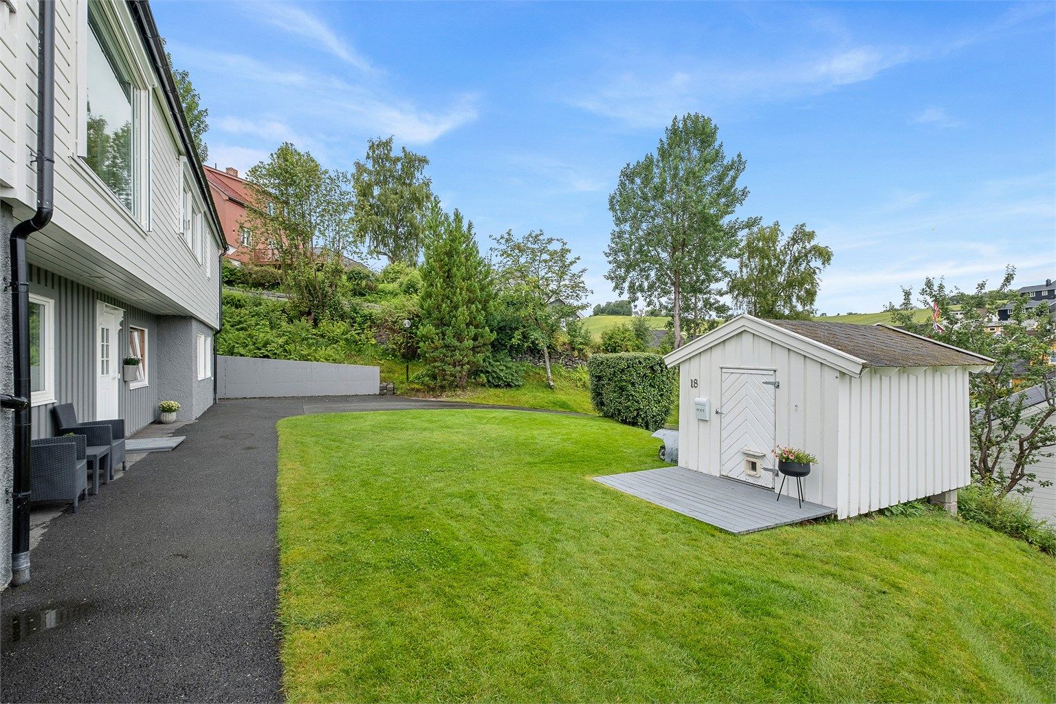 Parkmessig opparbeidet tomt og det er asfaltert rundt deler av huset. I tillegg har boligen en utvendig bod på ca. 20 kvm samt en sjarmerende dukkestue.