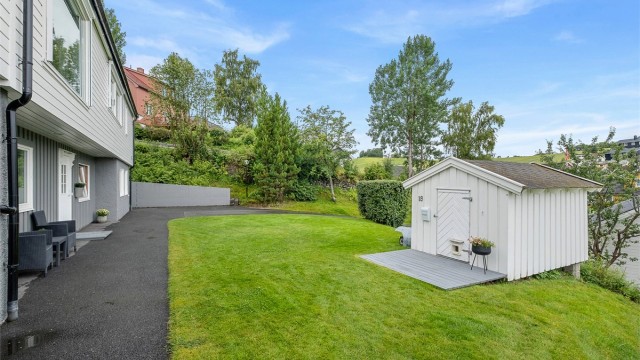 Parkmessig opparbeidet tomt og det er asfaltert rundt deler av huset. I tillegg har boligen en utvendig bod på ca. 20 kvm samt en sjarmerende dukkestue.