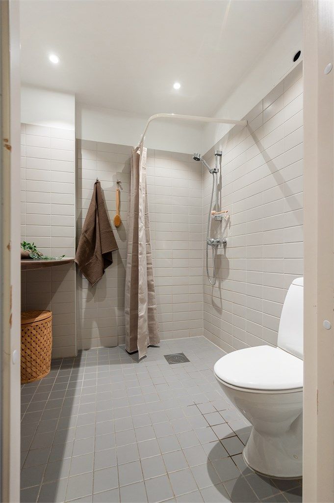 Dusjnisje med ett-greps dusjarmatur på vegg. 