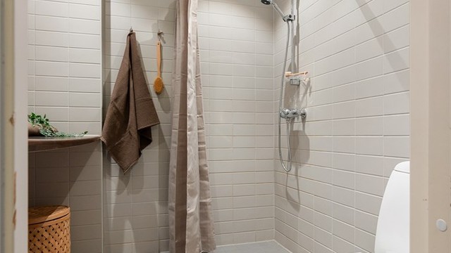 Dusjnisje med ett-greps dusjarmatur på vegg.