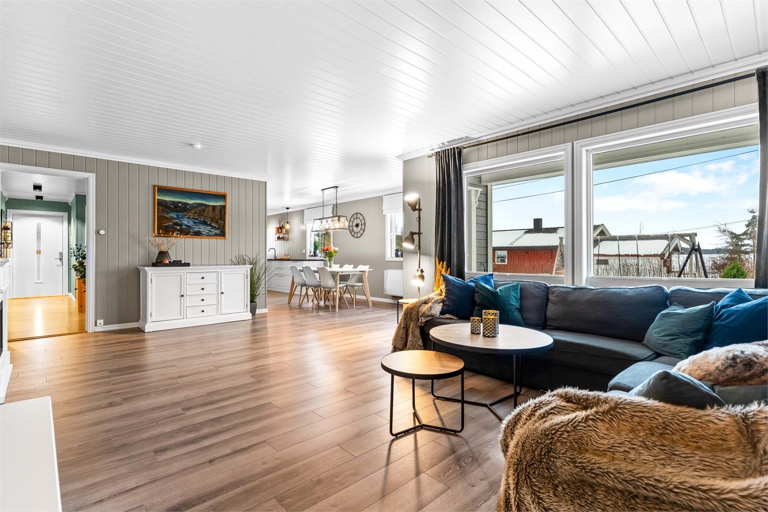 Den romslige stuen har store vindusflater som gir rikelig med naturlig lys.