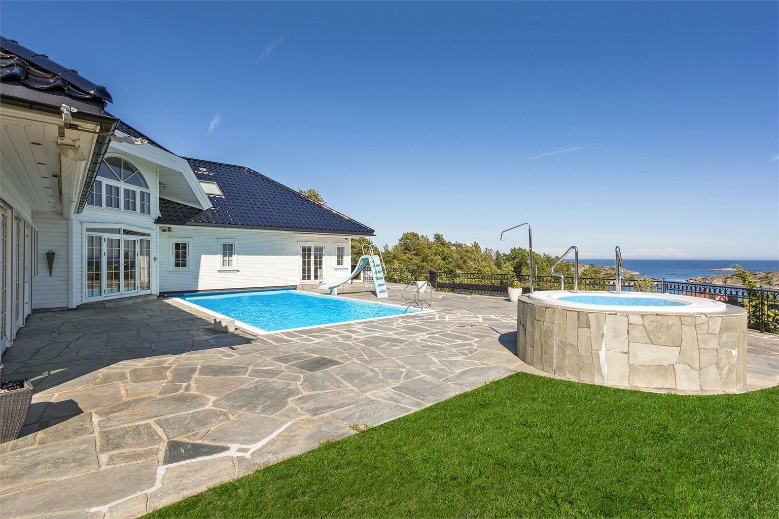 Fantastisk uteplass med fritt utsyn, basseng som har motstrømspumpe, boblebad, skiferbelagt uteplass, smijernsgjerde, utebelysning og beplantninger for å nevne noe av hva eiendommen byr på