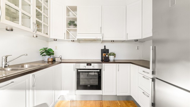 Klassisk kjøkkeninnredning med hvite profilerte fronter. Det er installert fuktsensor til automatisk vannstopper under oppvaskkum.