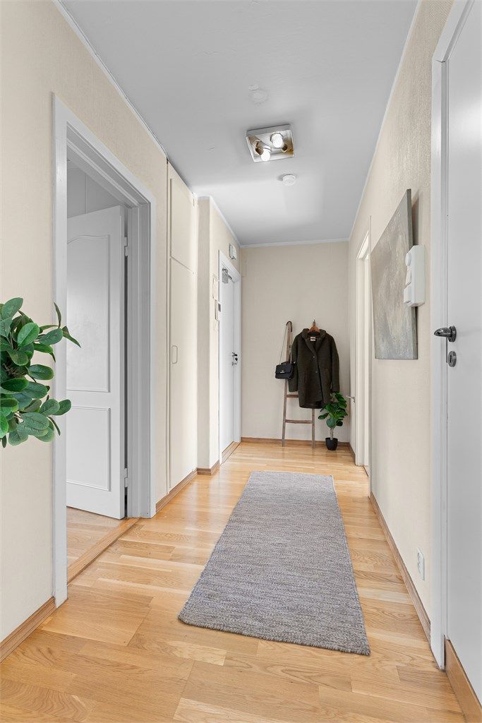 Gang med parkett på gulv og innebygd garderobeskap