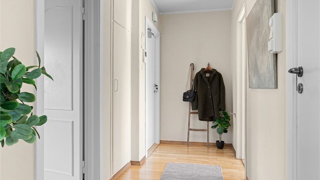 Gang med parkett på gulv og innebygd garderobeskap