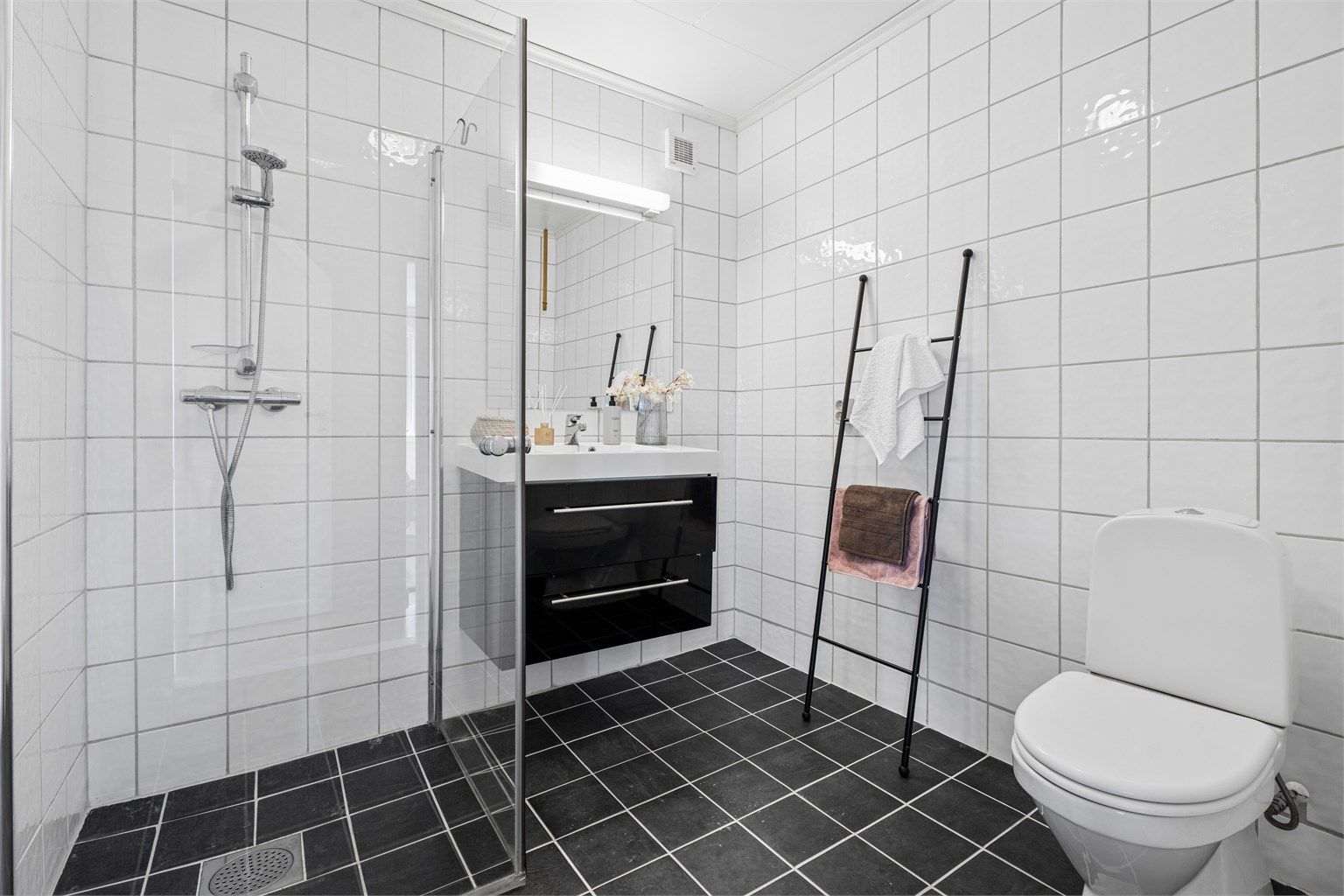 Badet i underetasjen ble oppgradert i 2013 og har flislagte overflater med gulvvarme, sertvant med underskap, dusjhjørne med glassdører og toalett.