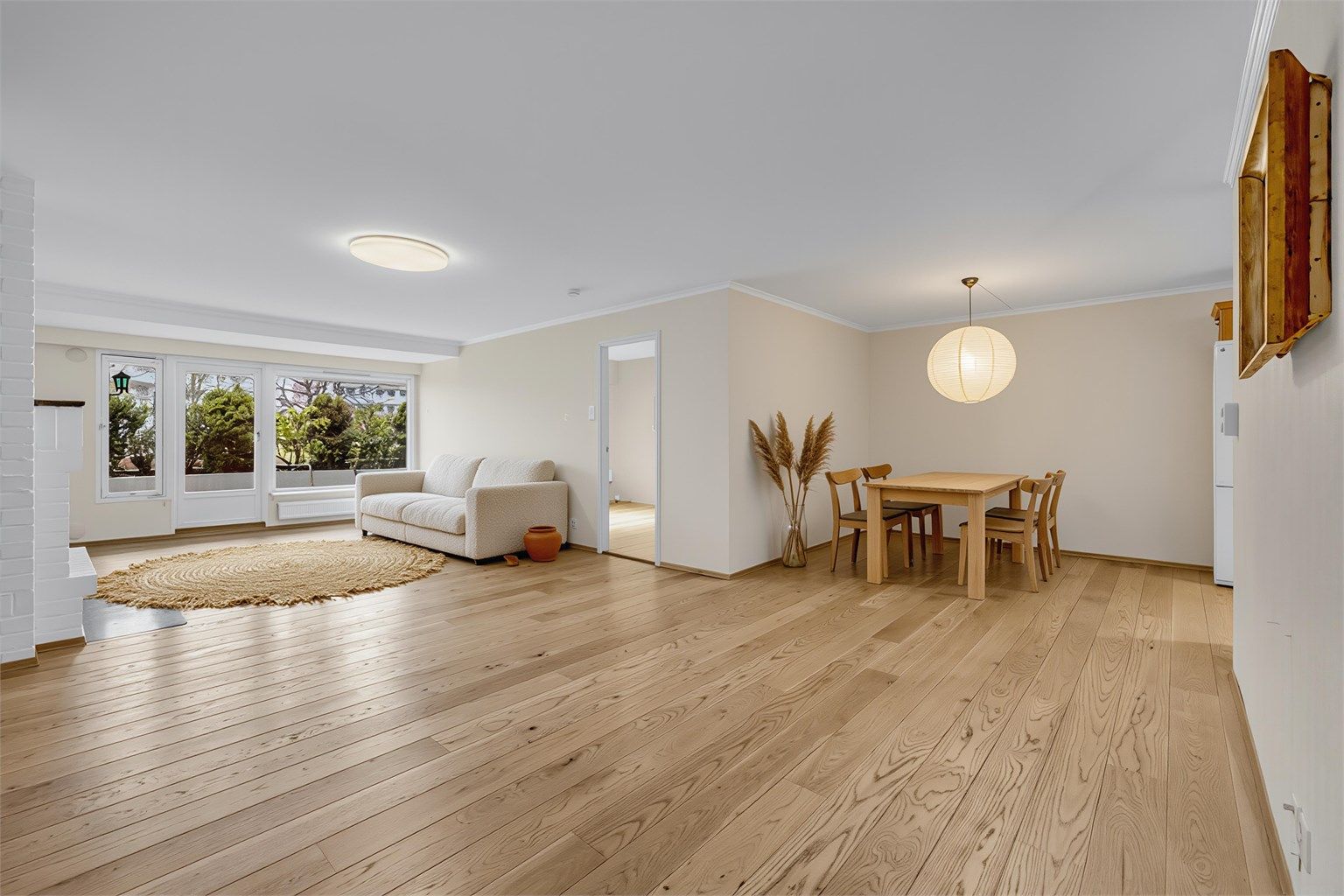 Stuen er romslig med lysmalte vegger og pene en-stavs parkettgulv. Digitalt stylet bilde.