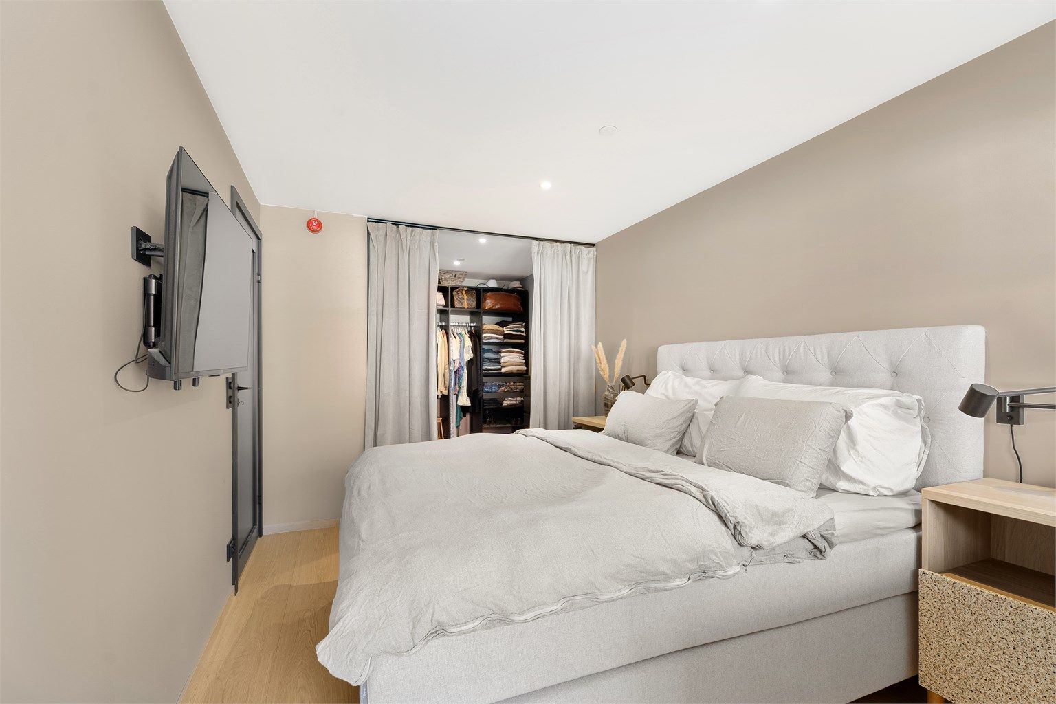 Det er laget en praktisk walk-in garderoe med skinner i tak og gardiner slik at det lett kan lukkes. 