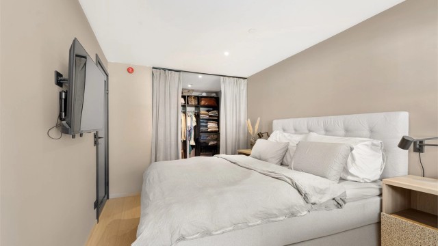 Det er laget en praktisk walk-in garderoe med skinner i tak og gardiner slik at det lett kan lukkes.