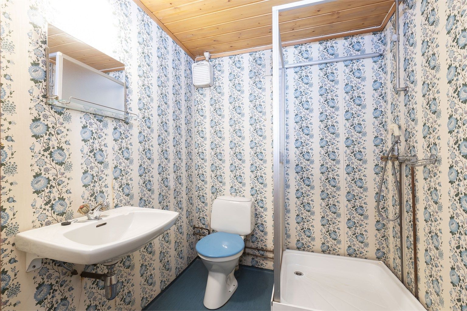 Bad i underetasje også fra byggeår. Gulvbelegg på gulv, servantinnredning og dusjkabinett.