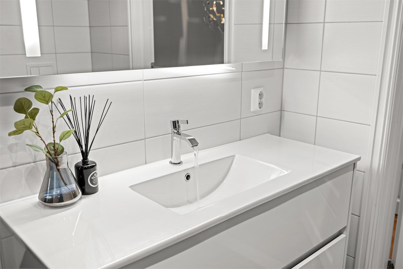 Innredningen har heldekkende servant og speil med integrert lys og stikkontakt.