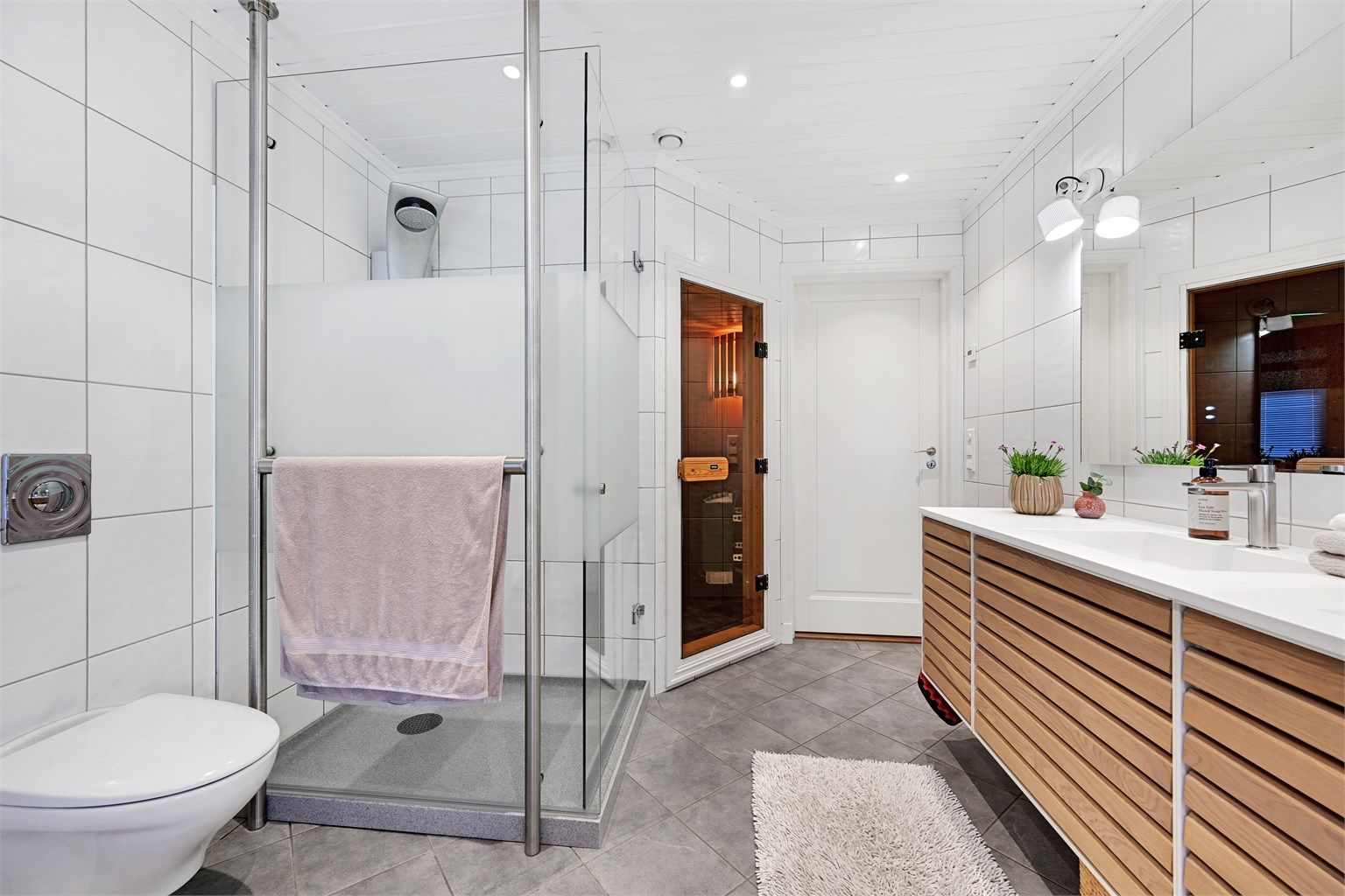 Dusjsonen har glassvegger og et spesialtilpasset oppsamlingskar for dusjvann.