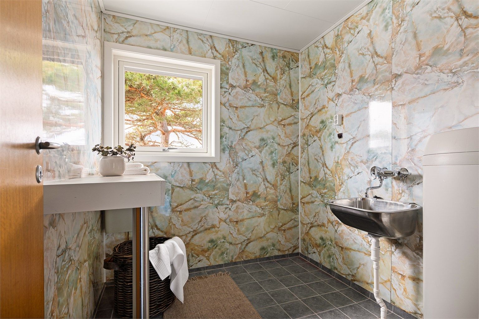 Vaskerommet er fra byggeåret og naturlig gjenstand for modernisering, men funksjonelt. Fliser er lagt på gulvet i nyere tid. I gulvet er det også varme.