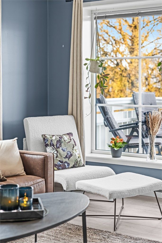 God plass til en behagelig lenestol i lyset ved balkongvinduet.