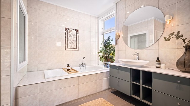 Lekker, vegghengt innredning. Legg også merke til vinduer på begge sider av badekaret. Dette var arkitektens ønske for at man skal kunne se hele veien gjennom huset.