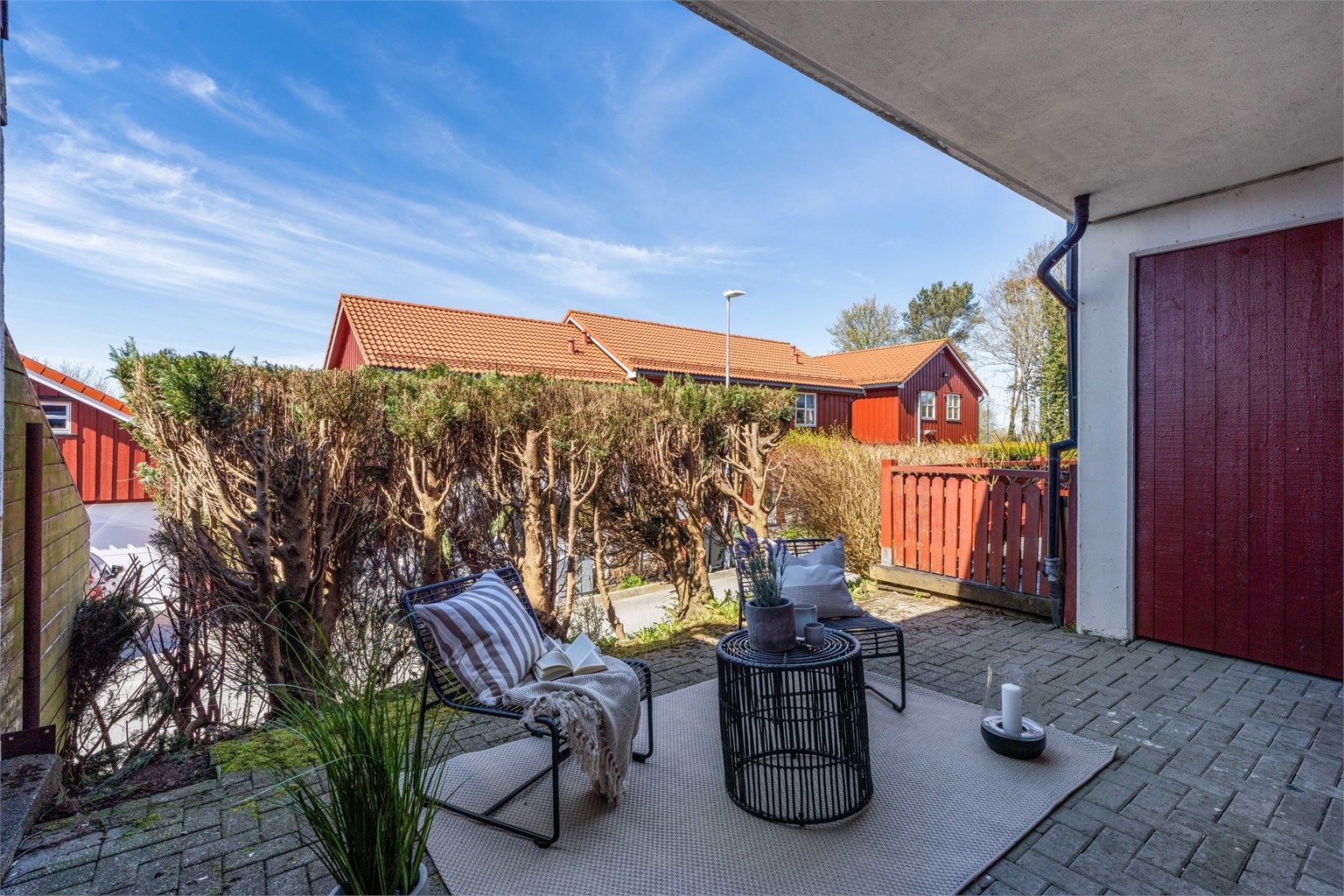 Fra stuen er det direkte utgang til en skjermet markplatting med belegningsstein, et privat uterom for avslapning.