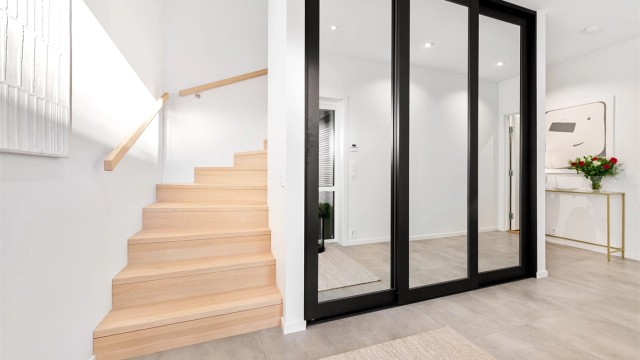 Hall/trapperom i underetasjen med stor skyvedør til garderoberom