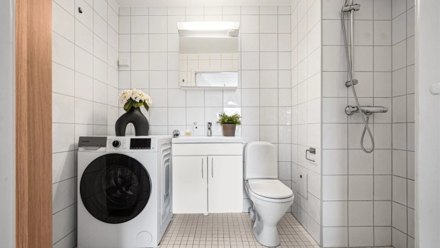 Et flislagt bad med gulvvarme og opplegg for vaskemaskin gir en praktisk og komfortabel hverdag.