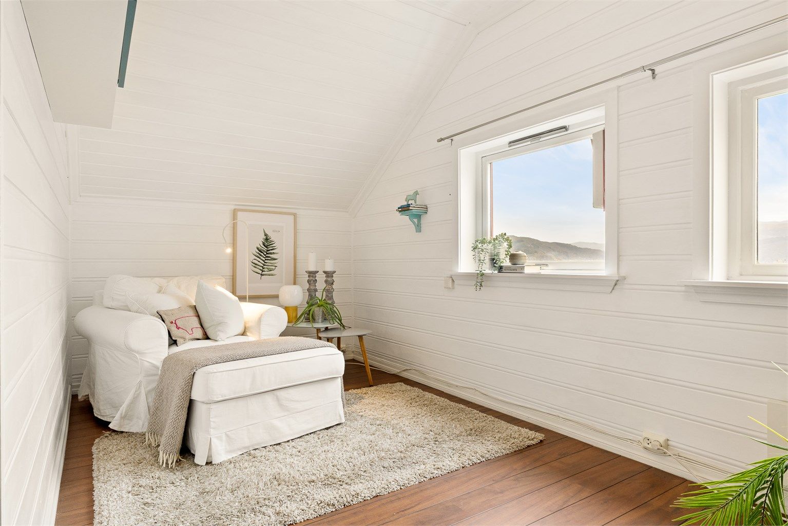 Malt platekledning av panel i både vegg og tak skaper en koselig atmosfære i stuen.