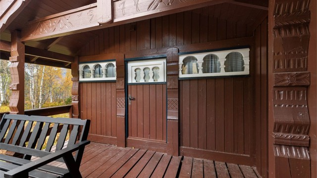 Overbygd terrasseparti med tradisjonsrike treutskjæringer.