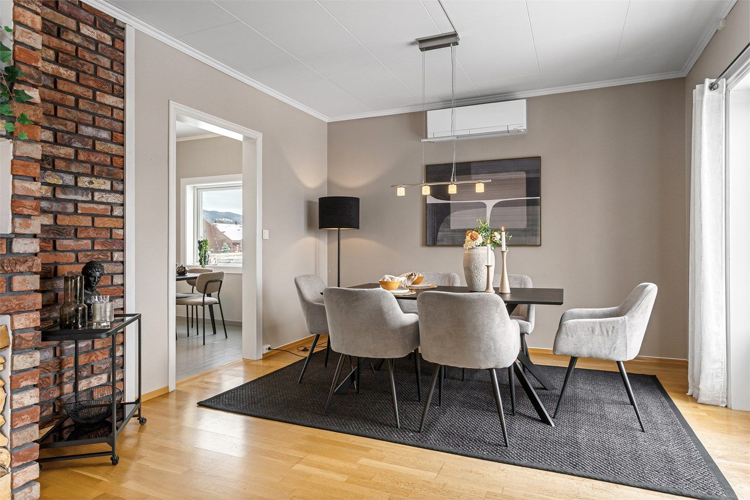 Lys stue med plass til sofagruppe og spisebord. 