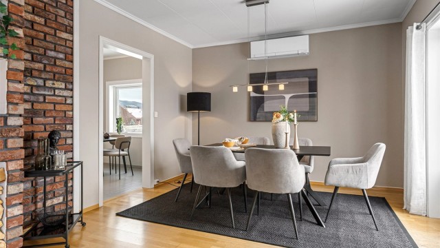 Lys stue med plass til sofagruppe og spisebord.