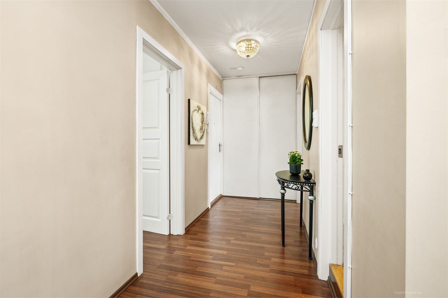 Praktisk skyvedørsgarderobe i entré med oppbevaringsplass.