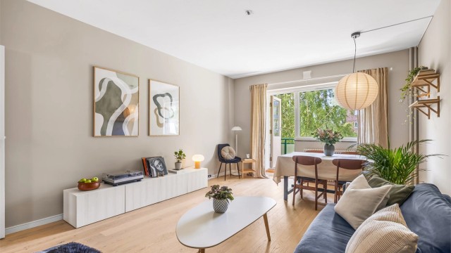 Den store og lyse stuen rommer plass til sofagruppe, bord og TV-benk, kontorplass og i tillegg til et sosialt spisebord.