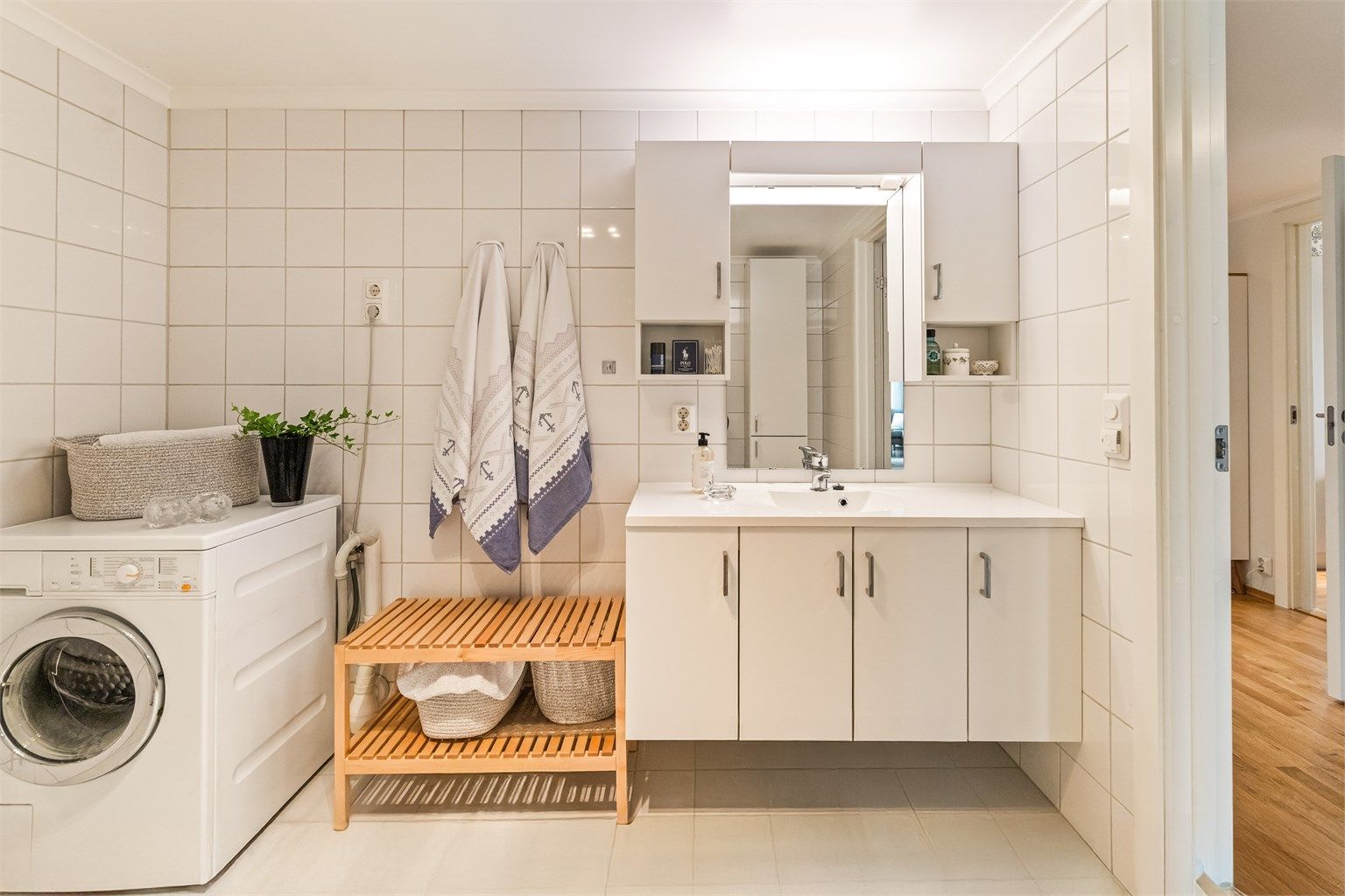 Pent, flislagt bad med opplegg til vaskemaskin.