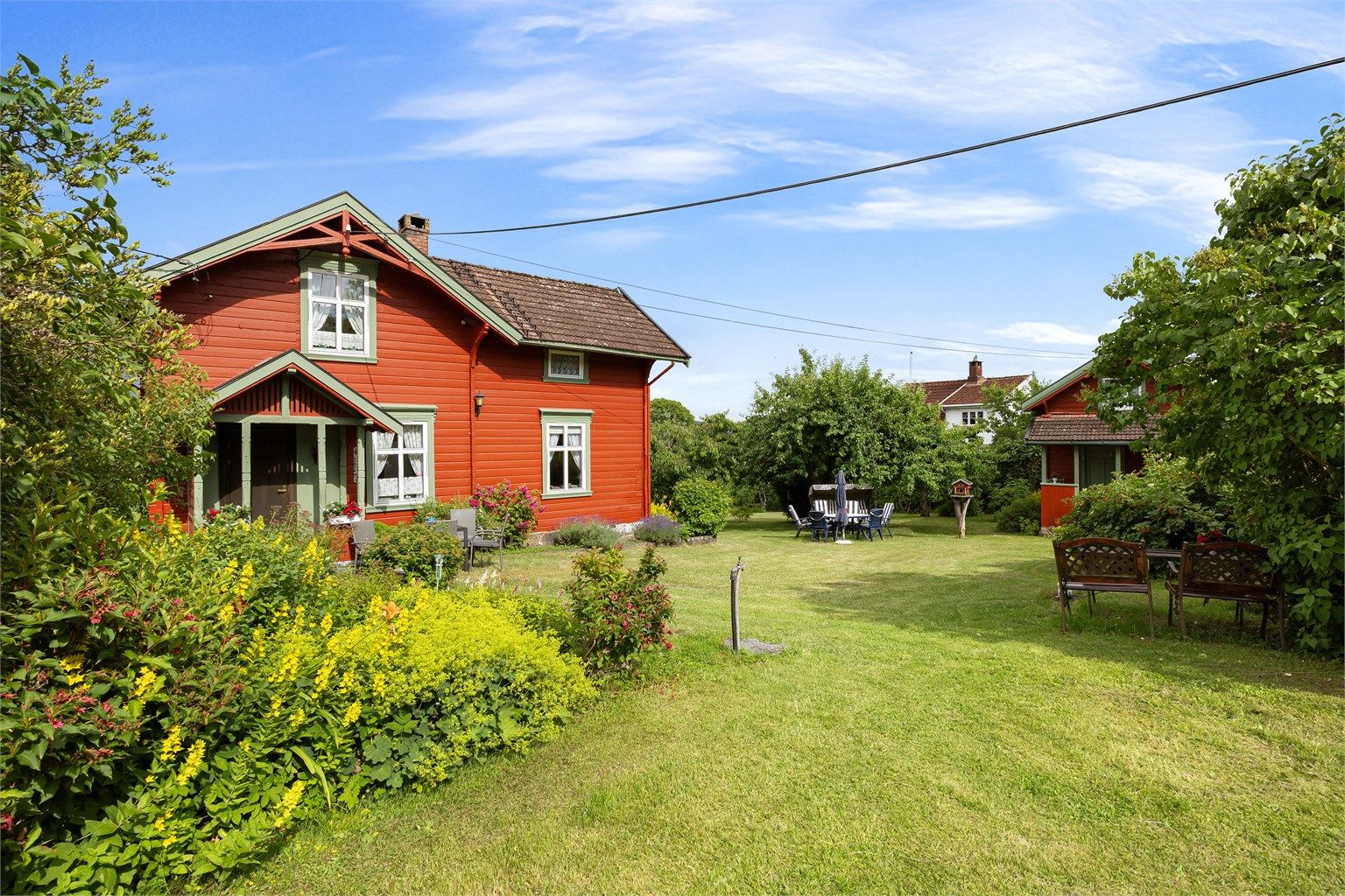 Eiendommen består av en fritidsbolig, anneks, hytte og uthus, omkranset av en stor hage.