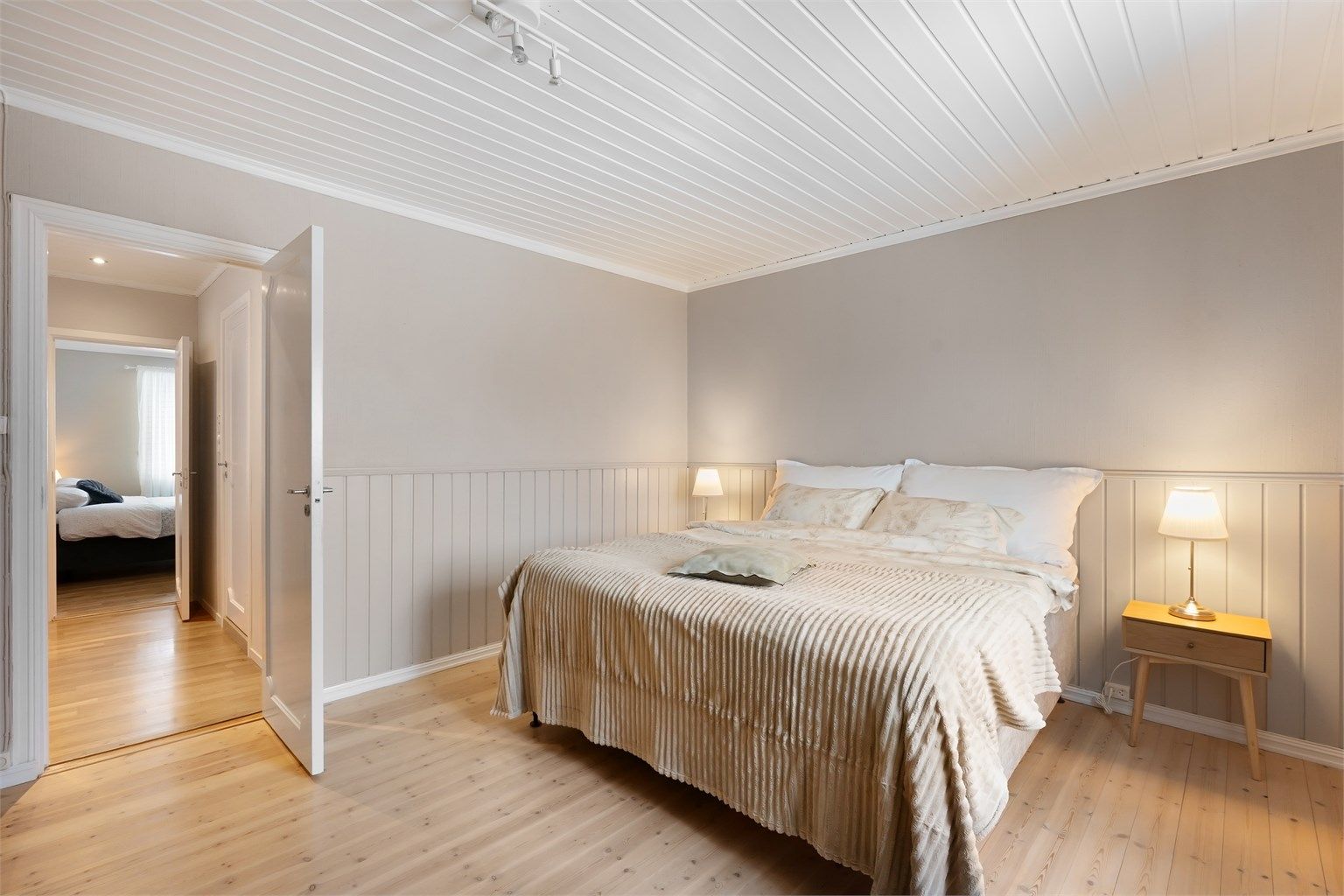 Rommet har originale gulvbord av tre og vegger med brystningspanel.